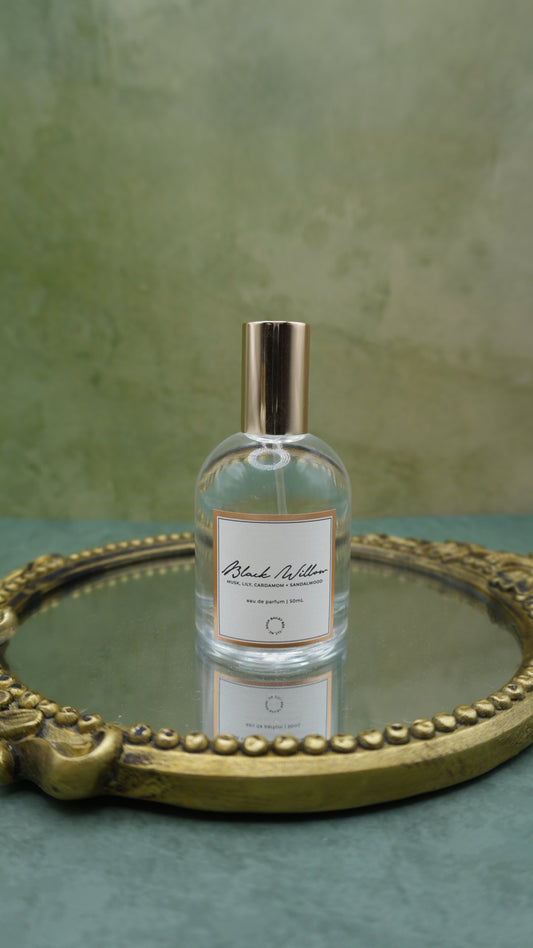 Bailey Bee Black Willow Eau de Parfum 50ml bottle with gold cap on an antique gold mirrored tray, notes of musk, lily, cardamom and sandalwood